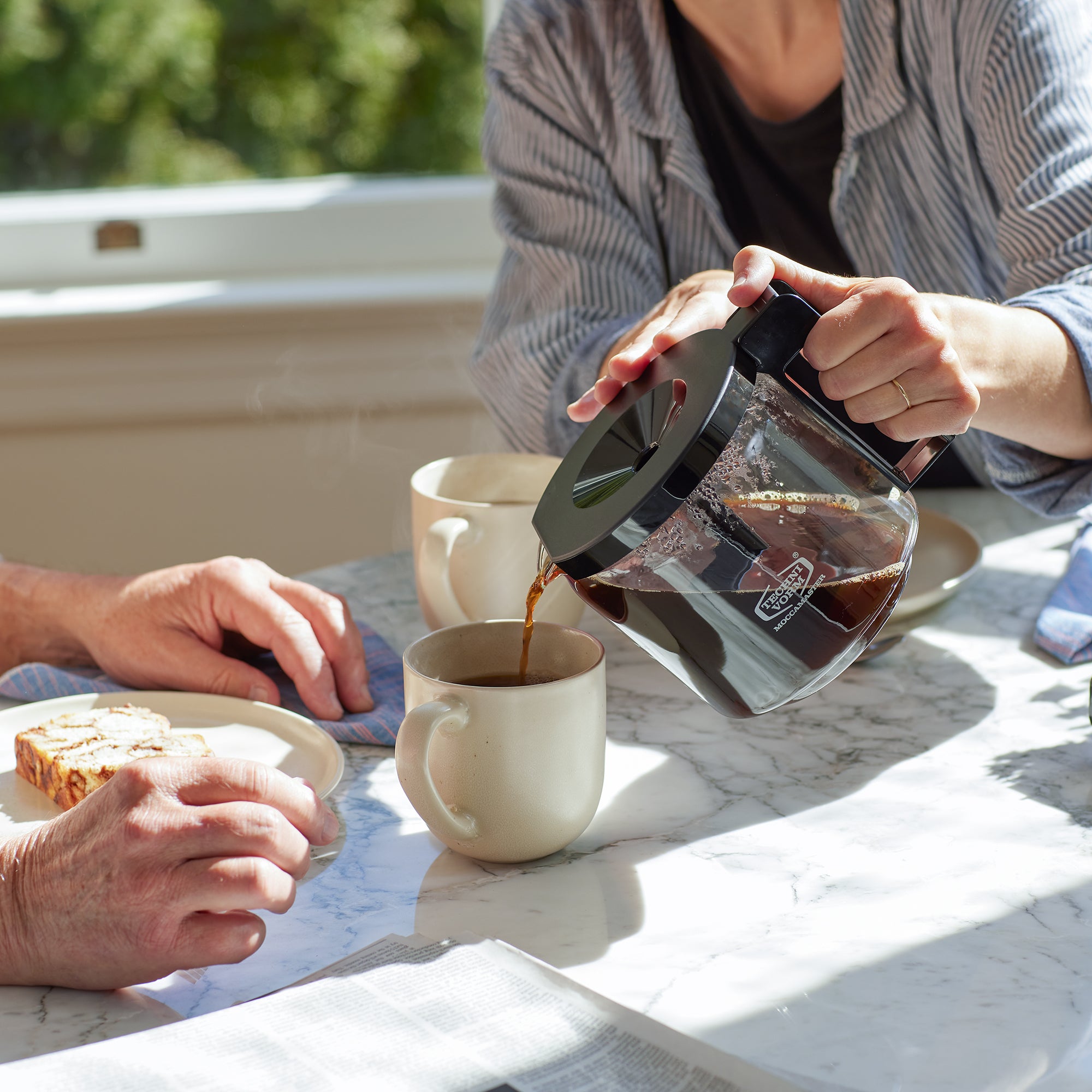 Hot coffee being poured into a mug.